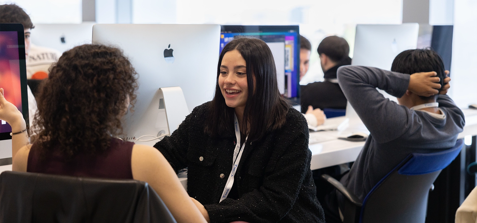 Dos estudiantes mujeres en IT colaboran junto a los ordenadores del campus de programación 42 Madrid Fundación Telefónica.