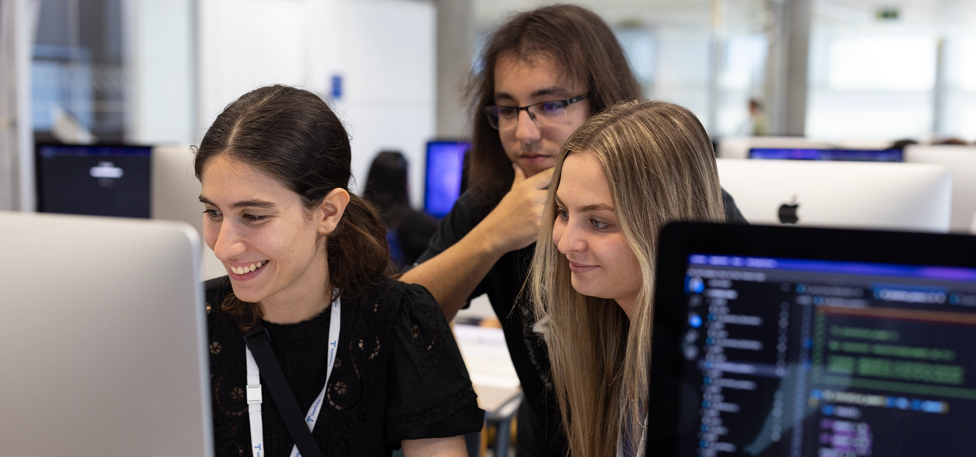 Tres estudiantes colaboran para resolver un ejercicio de programación mediante la metodología peer-to-peer en el campus 42 Madrid Fundación Telefónica.